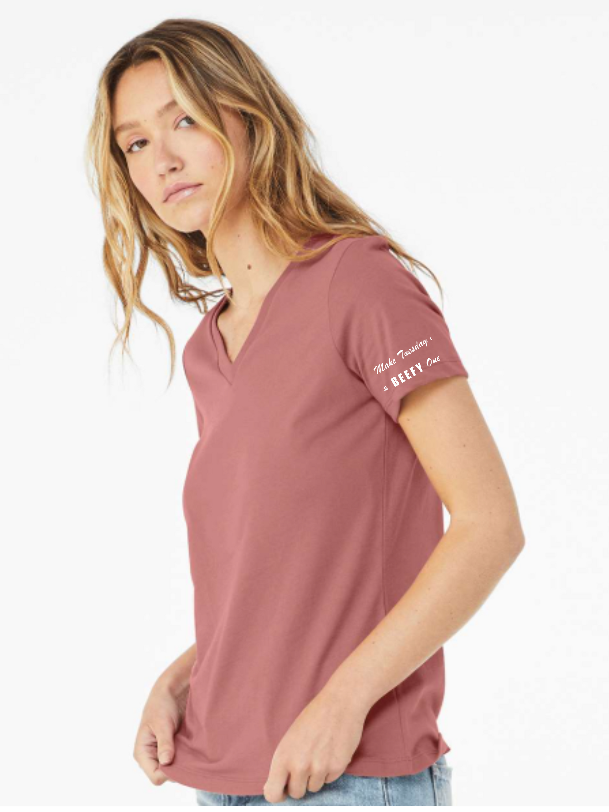 Woman wearing a pink t-shirt with text on the sleeve against a white background