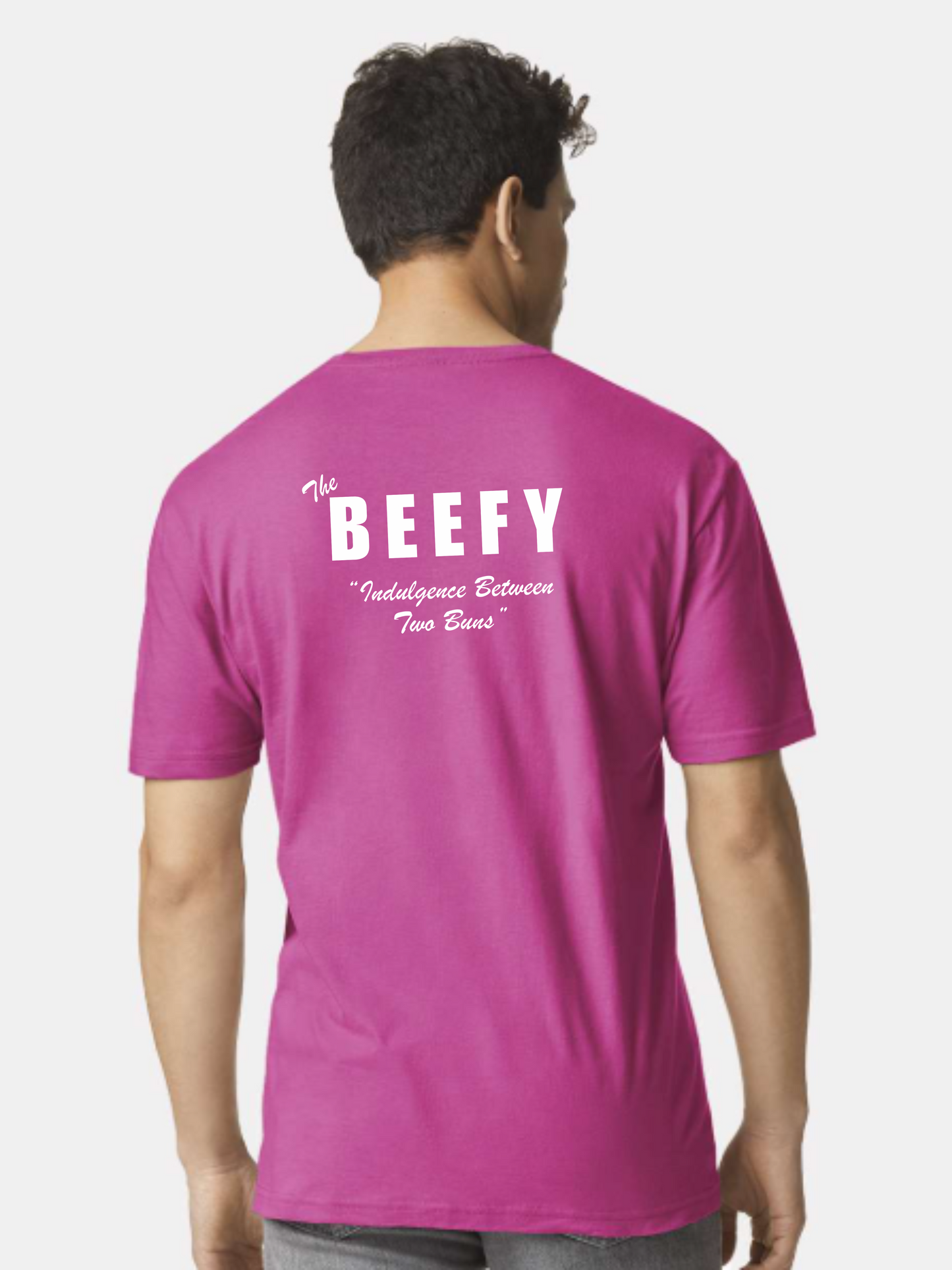 Person wearing a pink t-shirt with 'The BEEFY' text on the back against a white background